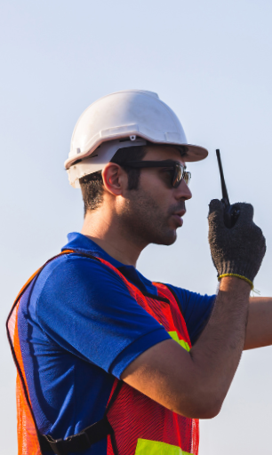 Image of construction crew member using handheld radio.